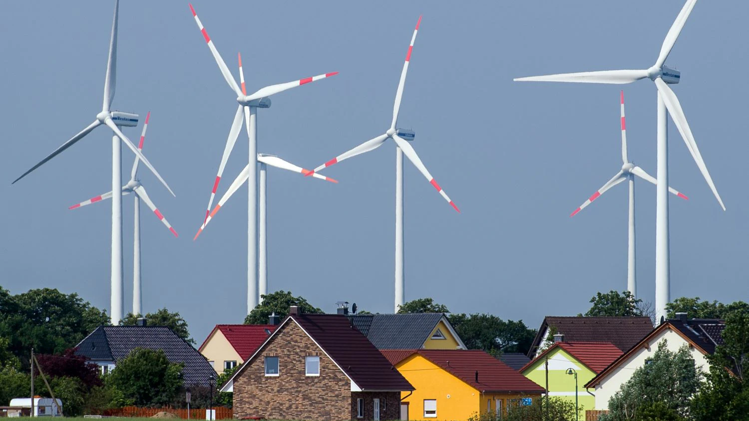 Dicht stehen die Windräder eines Windenergieparks an Einfamilienhäusern nahe Nauen (Brandenburg).