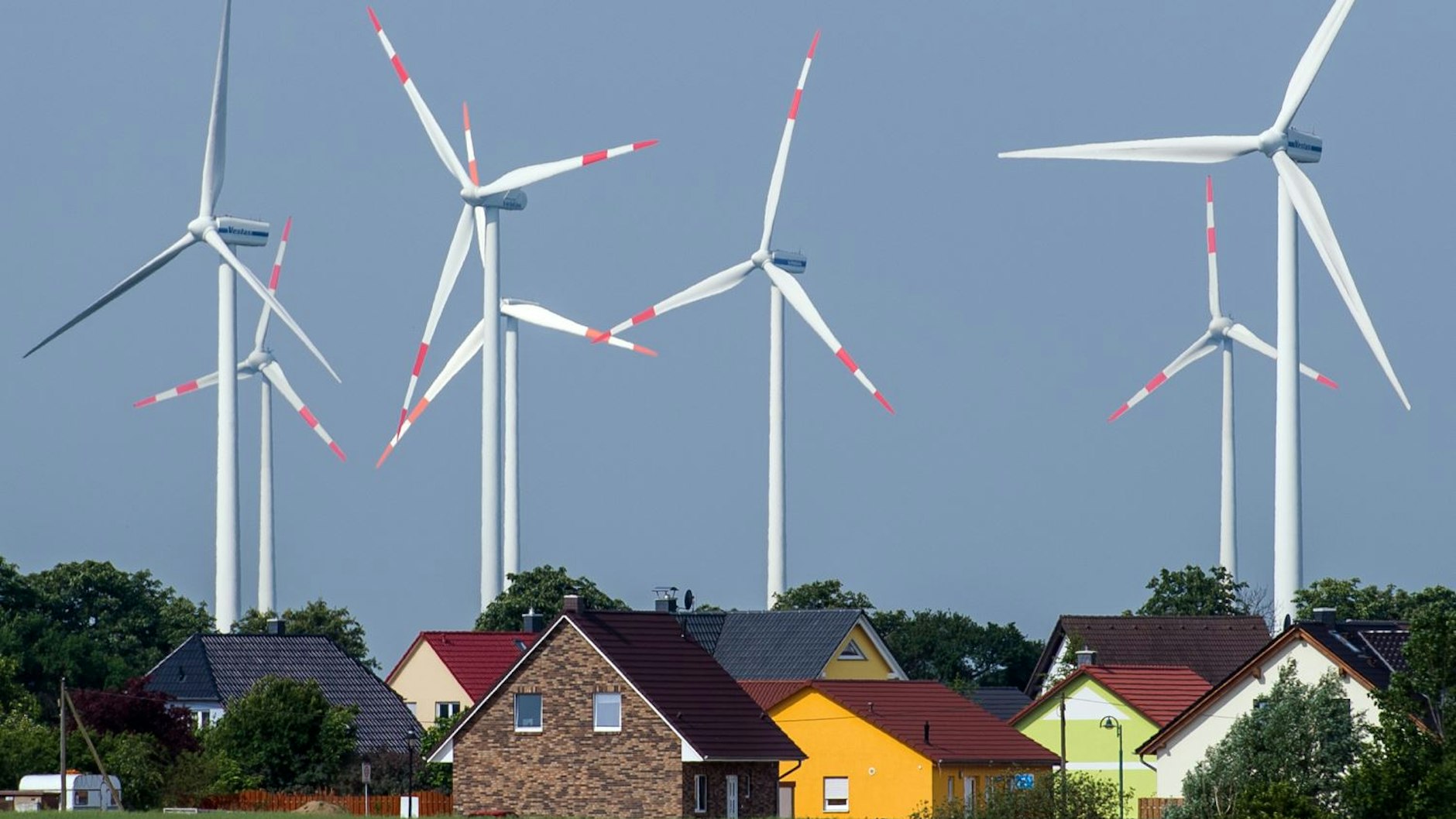 Dicht stehen die Windräder eines Windenergieparks an Einfamilienhäusern nahe Nauen (Brandenburg).