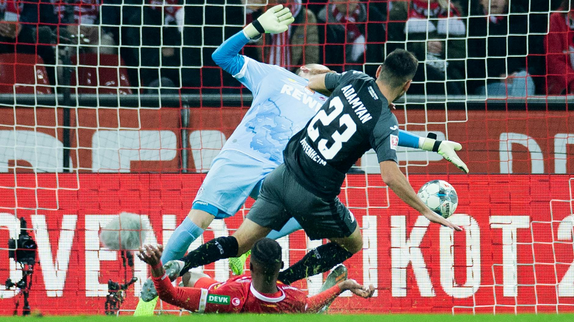 Hoffenheims Sargis Adamyan (23) trifft gegen Kölns Torwart Timo Horn und Kingsley Ehizibue. 