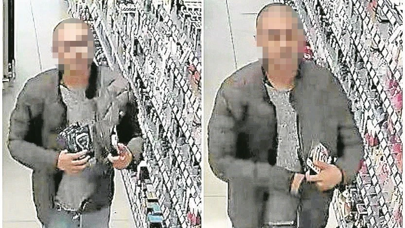Ein mutmaßliches Mitglied einer Bande lässt Kosmetikartikel in seiner Jacke verschwinden.