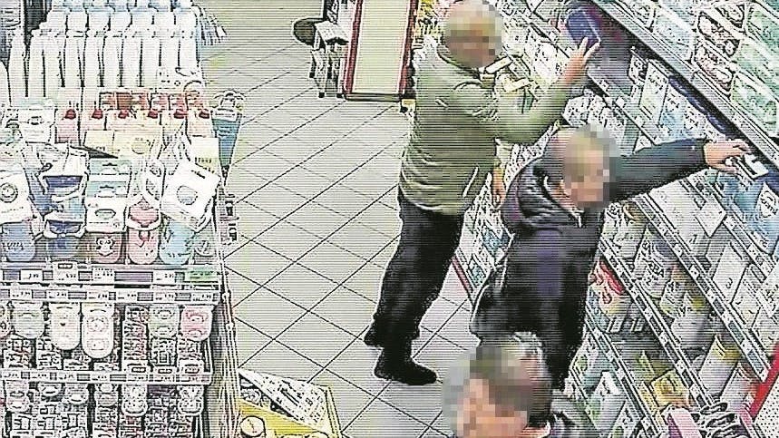 Die Bande von drei Georgiern bei der „Arbeit“: Zwei räumen Milchpulver aus dem Regal, einer deckt die Sicht ab und passt auf.