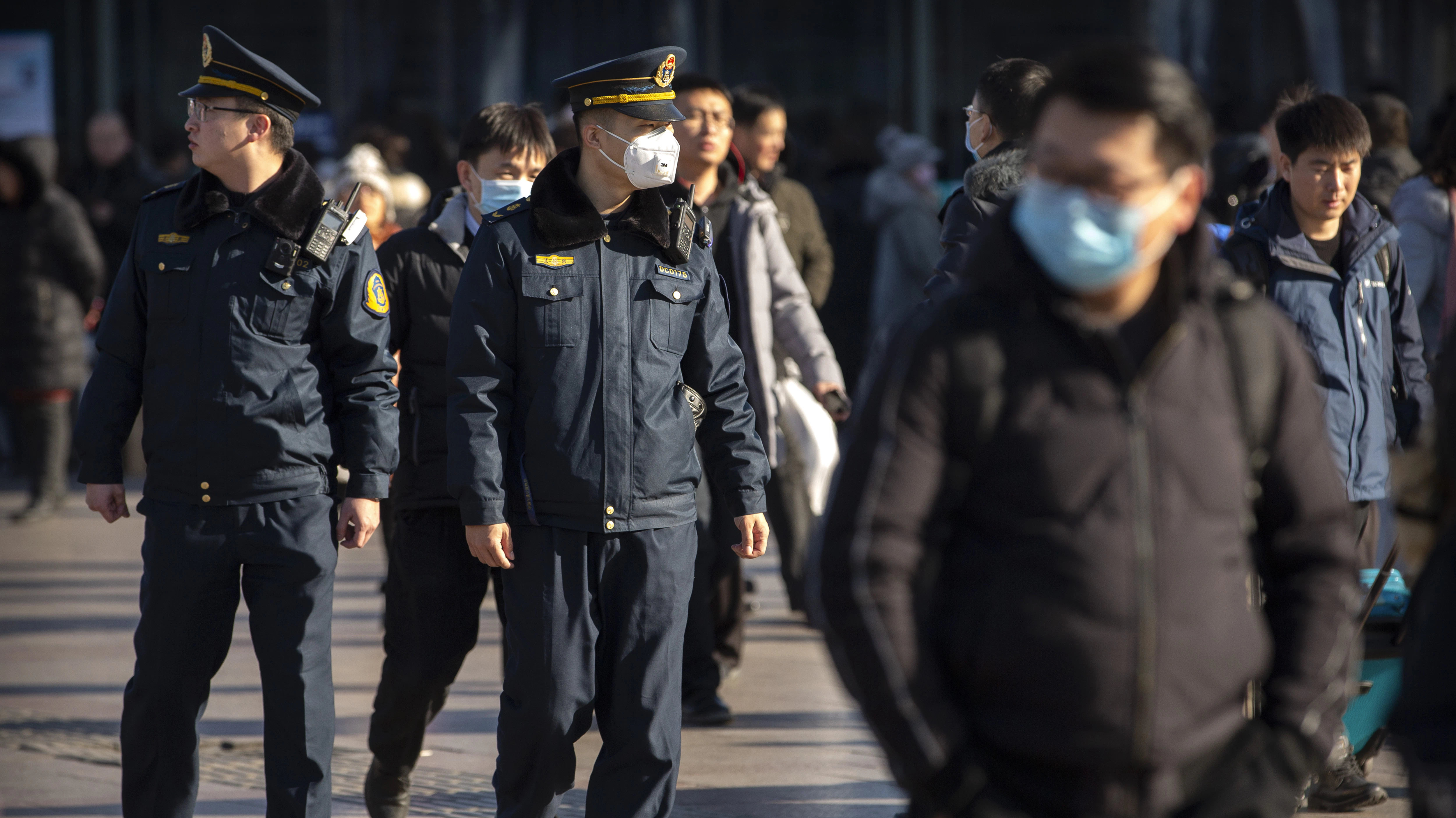 Vorsichtsmaßnahmen im ganzen Land: Polizisten und Passanten mit Mundschutz in Peking.