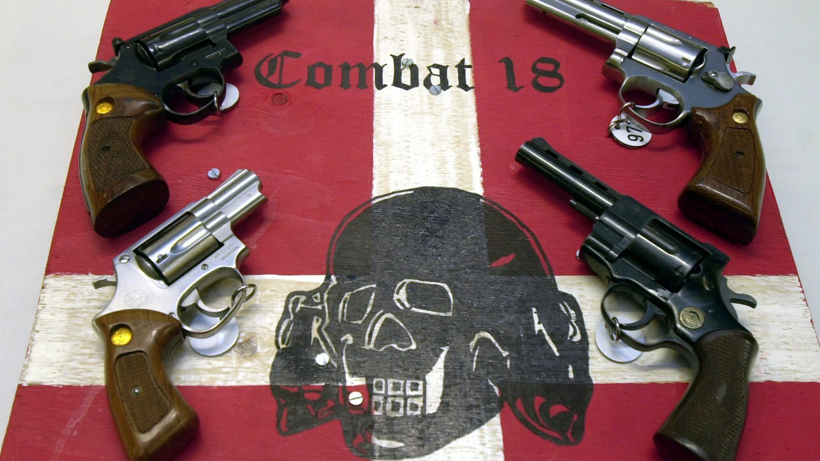 Sichergestellte Waffen und ein Schild der kriminellen Neonazi-Gruppe "Combat 18" liegen im schleswig-holsteinischen Landeskriminalamt (LKA).