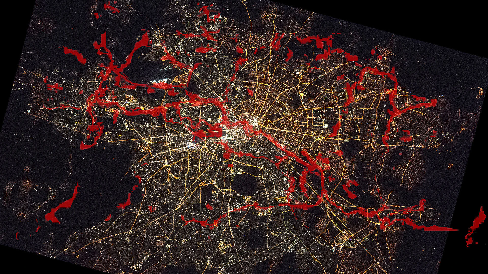 In diesem Foto, das Berlin bei Nacht vom Weltraum aus zeigt, haben die Wildtierforscher eingezeichnet, auf welchen Wegen Berliner Fledermäuse zwischen Tag- und Nachtquartier pendeln (rot). 