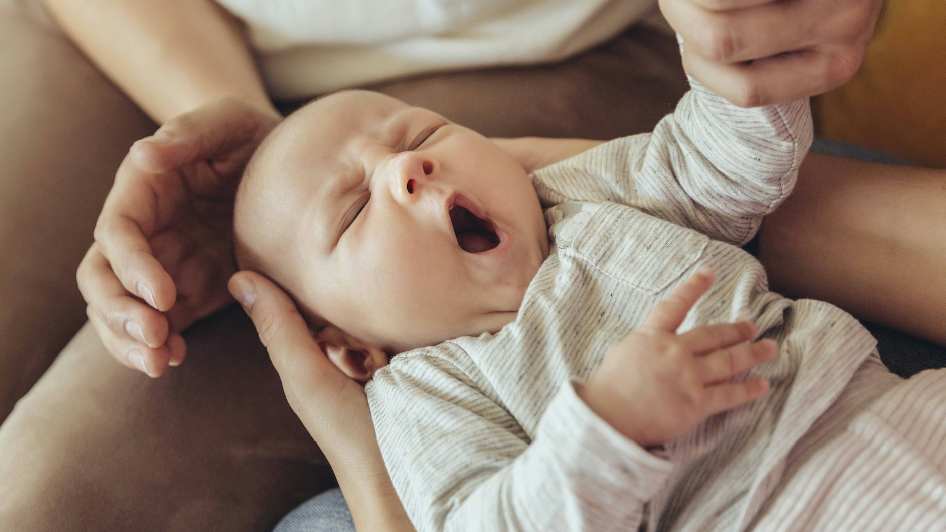 Eine Hebamme untersucht ein neugeborenes Baby (Symbolbild).