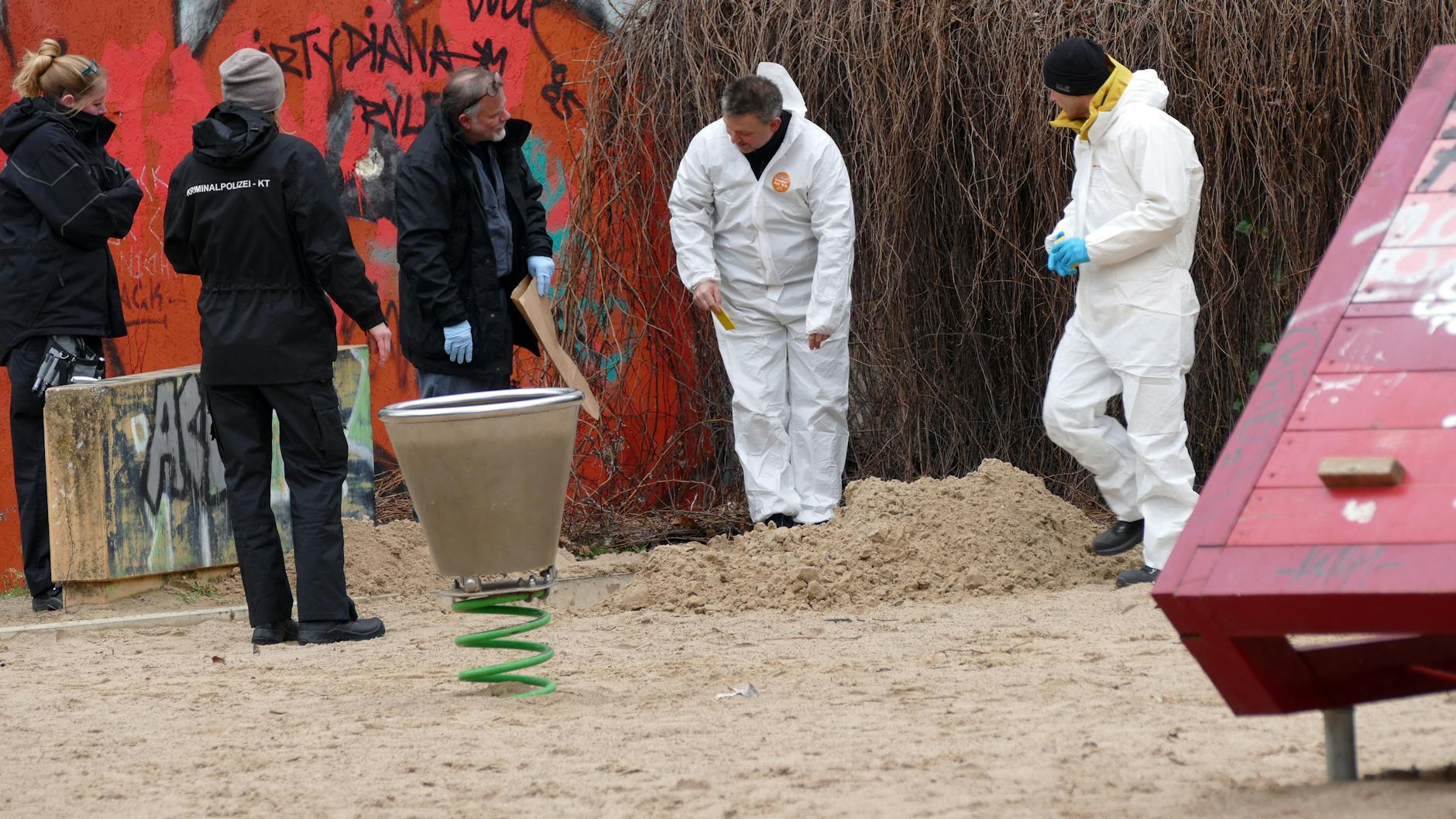 Ermittler der Spurensicherung an der ausgehobenen Grube auf dem Spielplatz.