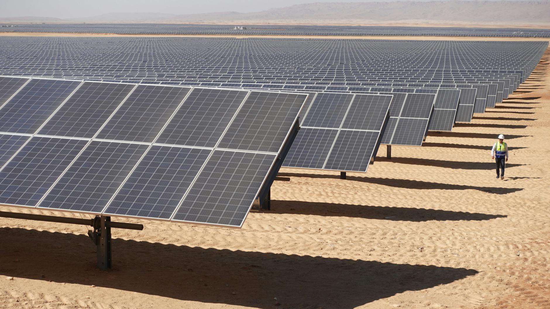 Arbeiter sind am Solarpark Benban in Ägypten unterwegs auf einer Landparzelle, an deren Entwicklung die deutsche Planungsfirma IB Vogt beteiligt war.