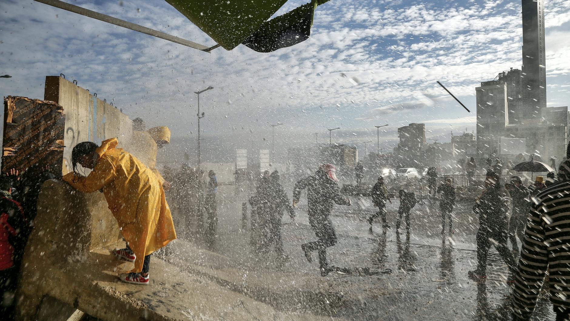 2.2.2020, Libanon, Beirut: Ein regierungsfeindlicher Demonstrant wird während eines Protestes in der Nähe des Parlaments von Soldaten der libanesischen Armee mit Wasser bespritzt.