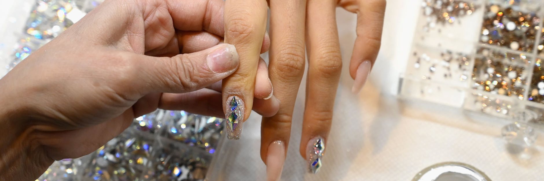 Jenny Bui bei der Arbeit, die Fingernägel einer Kundin werden aufwendig verziert.