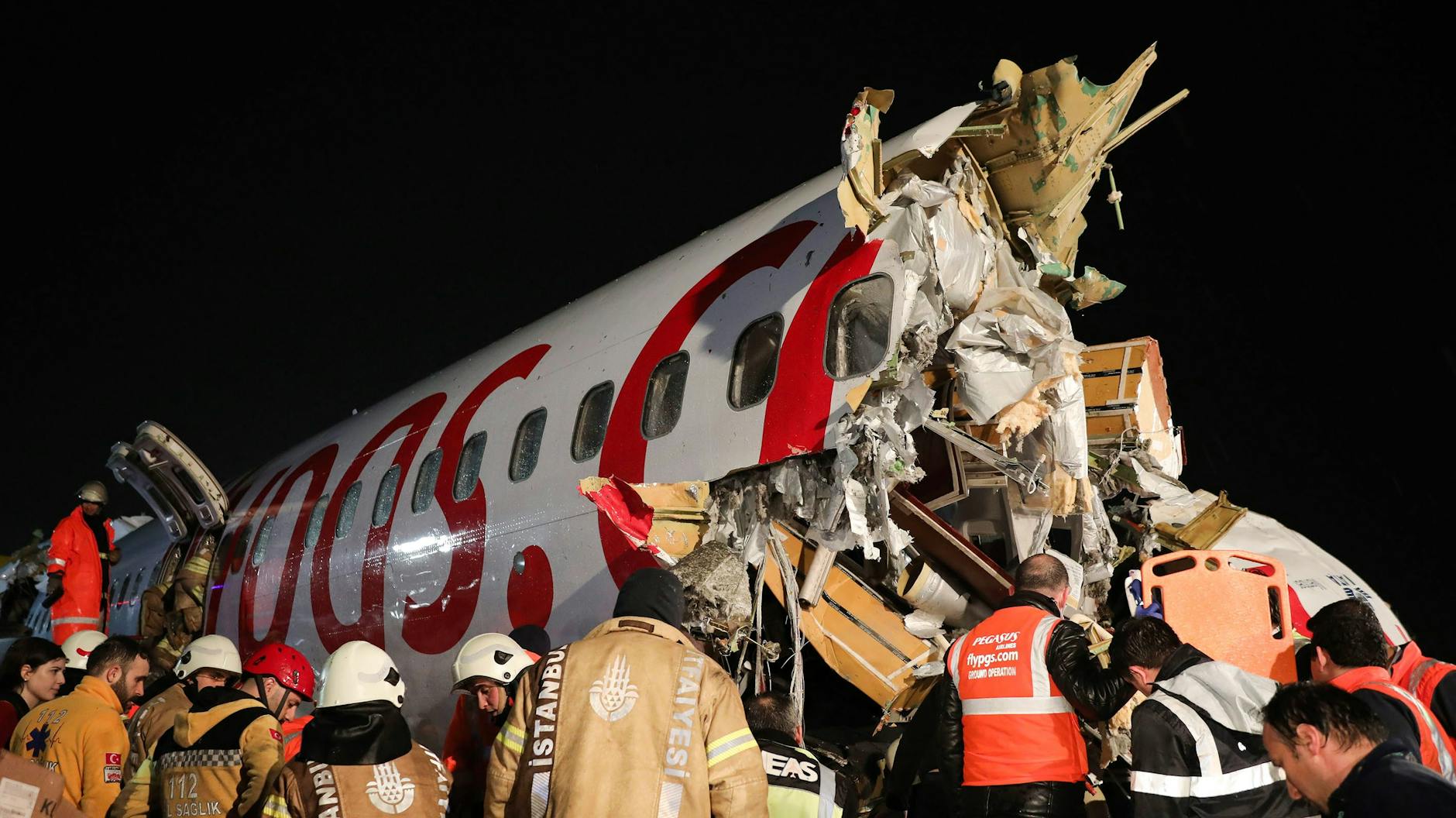Rettungskräfte stehen in der Nähe eines Flugzeugs, das am Flughafen Sabiha Gökcen von der Landebahn abgekommen ist und Feuer gefangen hat.