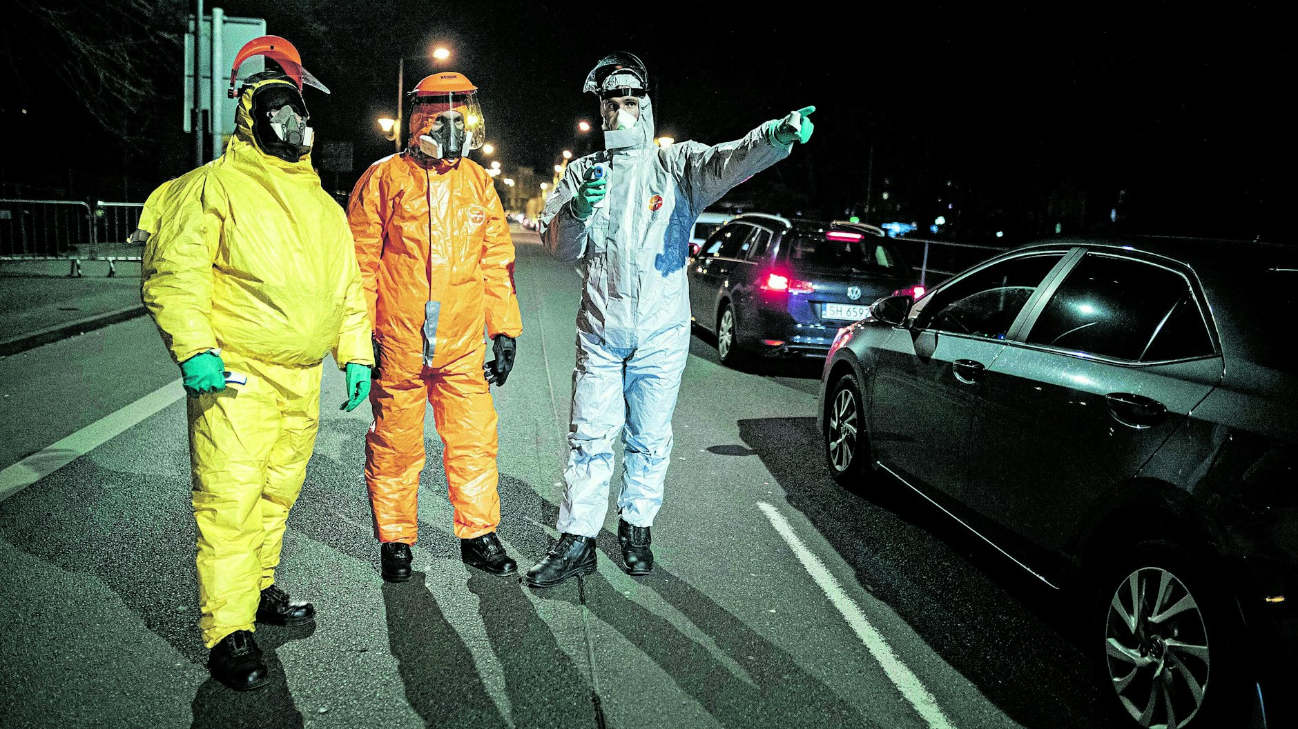Wie aus einem Katastrophenfilm: Männer in Schutzkleidung stehen an der deutsch-polnischen Grenze in Görlitz, um die Körpertemperatur von Einreisenden zu kontrollieren.