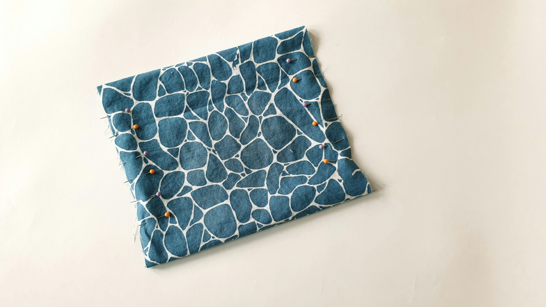 Dann wendet man den Stoff und setzt sich mit Stecknadeln Markierungen für die Falten.