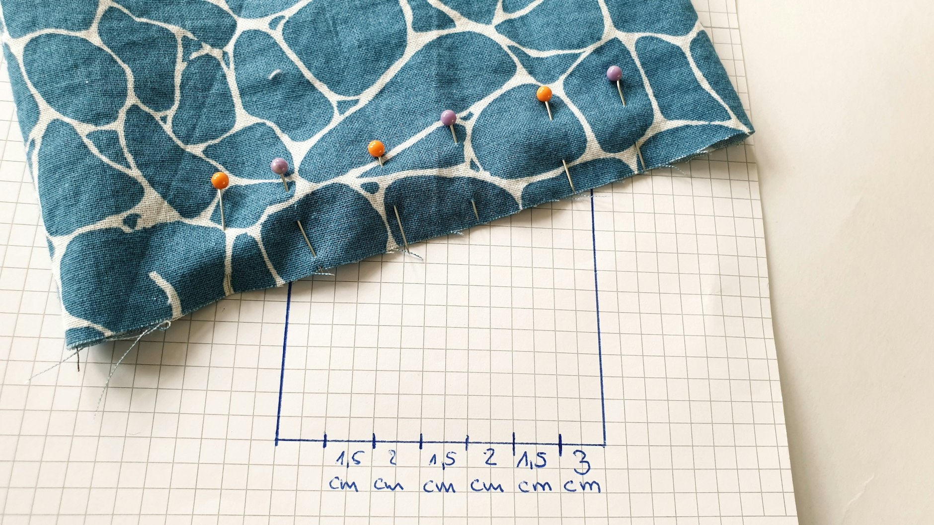 Zwei verschiedene Nadelfarben helfen dabei, später an der richtigen Stelle in die richtige Richtung zu falten. Die Abstände sind wie folgt: 3 cm von oben beginnend, 1,5cm, 2cm, 1,5 cm, 2cm, 1,5cm.