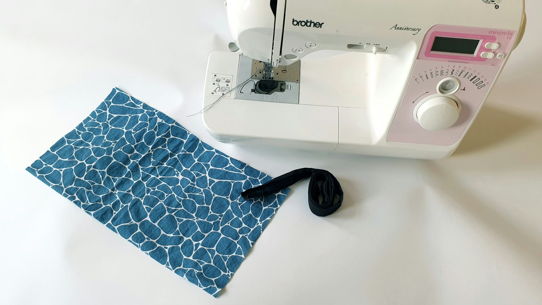 Man braucht ein Stück Baumwoll-Stoff (34x19 cm), 1,5 Meter Schrägband und eine Nähmaschine oder Nähnadel und Faden.