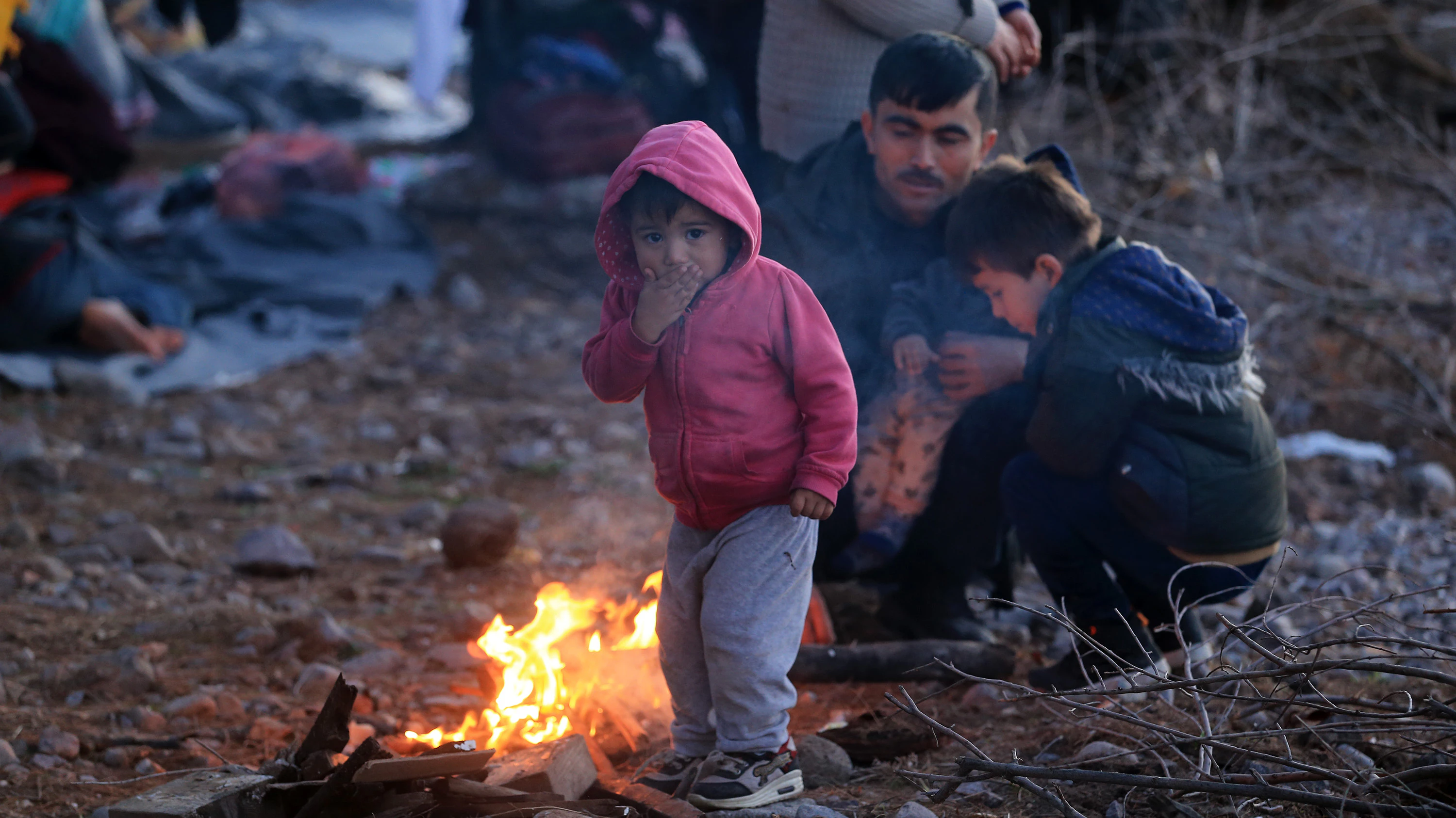 Ein Flüchtlingskind wärmt sich auf der Insel Lesbos an einem Feuer.