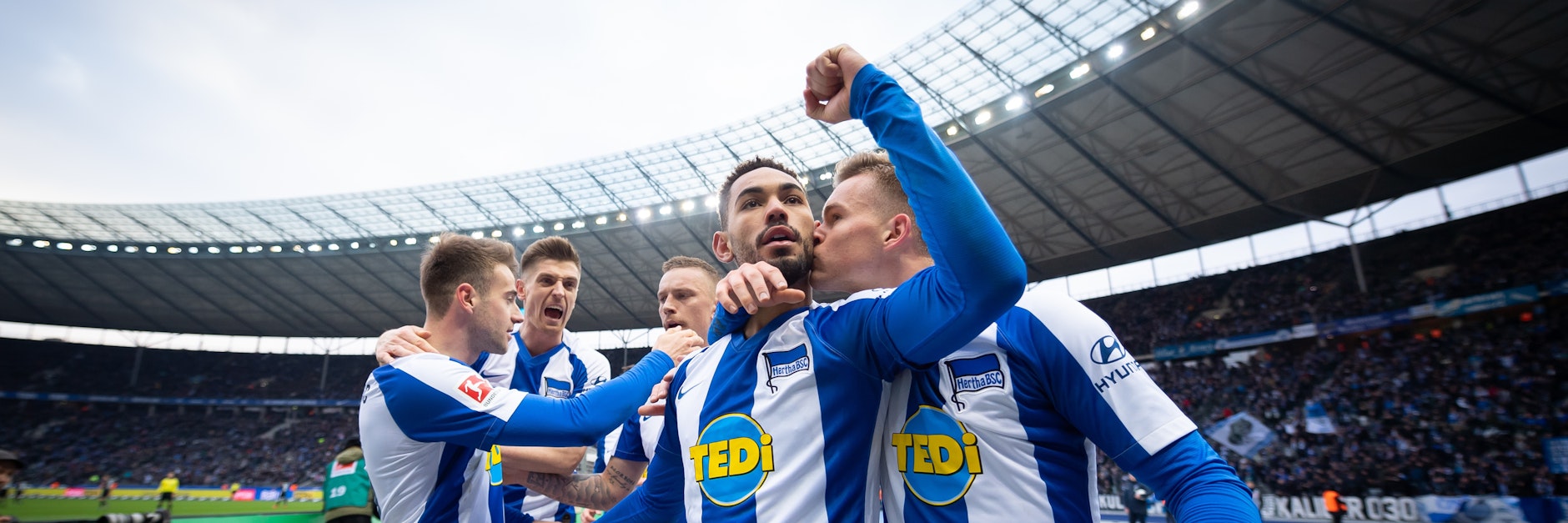 Matheus Cunha bekommt von Maximilian Mittelstädt einen dicken Schmatzer auf die Wange. Im Hintergrund feiern&nbsp;Lukas Klünter, Krzysztof Piatek, Marius Wolf (v.l.)