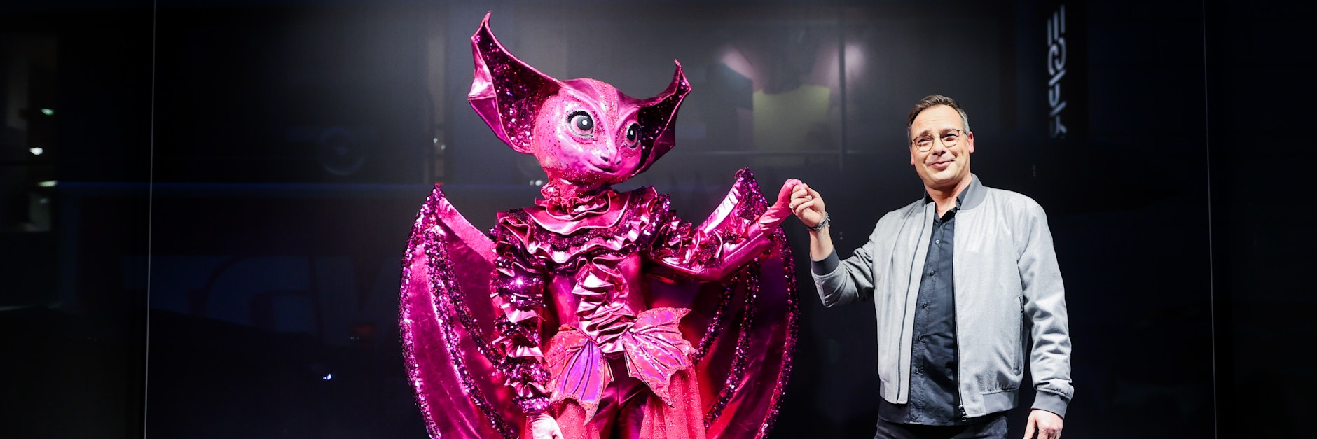 Die Figur "Die Fledermaus" steht in einem Schaufenster in der Innenstadt neben Moderator Matthias Opdenhövel.