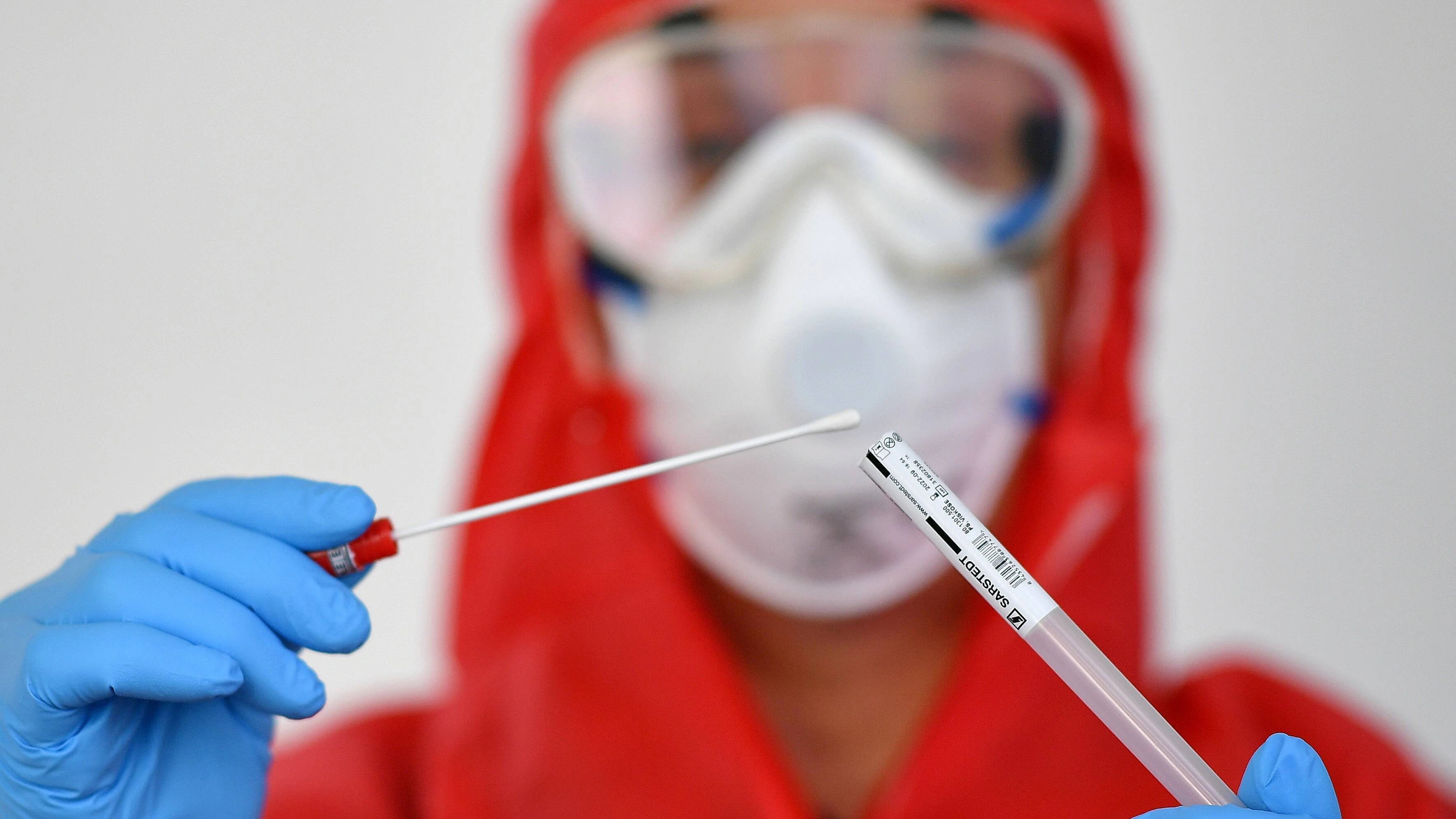Ein Mitarbeiter des Gesundheitsamtes mit einer Probe eines Corona-Tests.&nbsp;