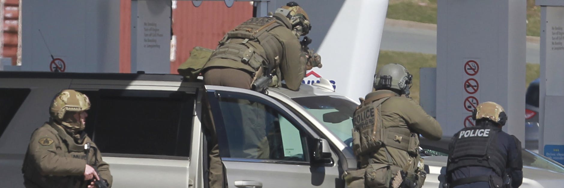 Polizisten bereiten sich darauf vor, an einer Tankstelle einen Verdächtigen in Gewahrsam zu nehmen. 