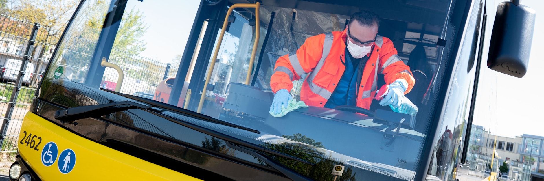 Mit Sprühflasche und Putztuch säubert ein BVG-Mitarbeiter an der Endhaltestelle Kurt-Schumacher-Platz einen Bus der Linie 125.
