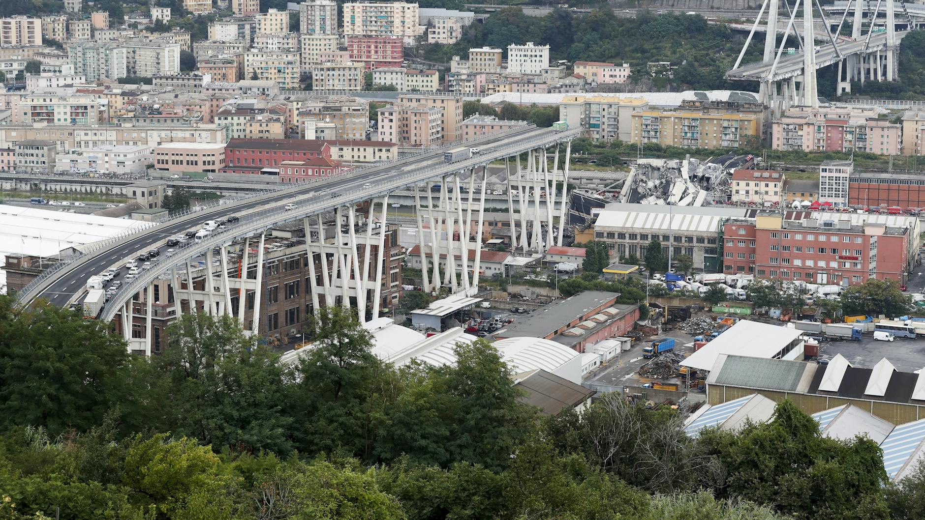 14. August 2018: Noch stehen Autos auf der teilweise eingestürzten Ponte Morandi. In der Mitte sieht man, wo die Brücke eingestürzt ist. 43 Autofahrer stürzten mit in die Tiefe.