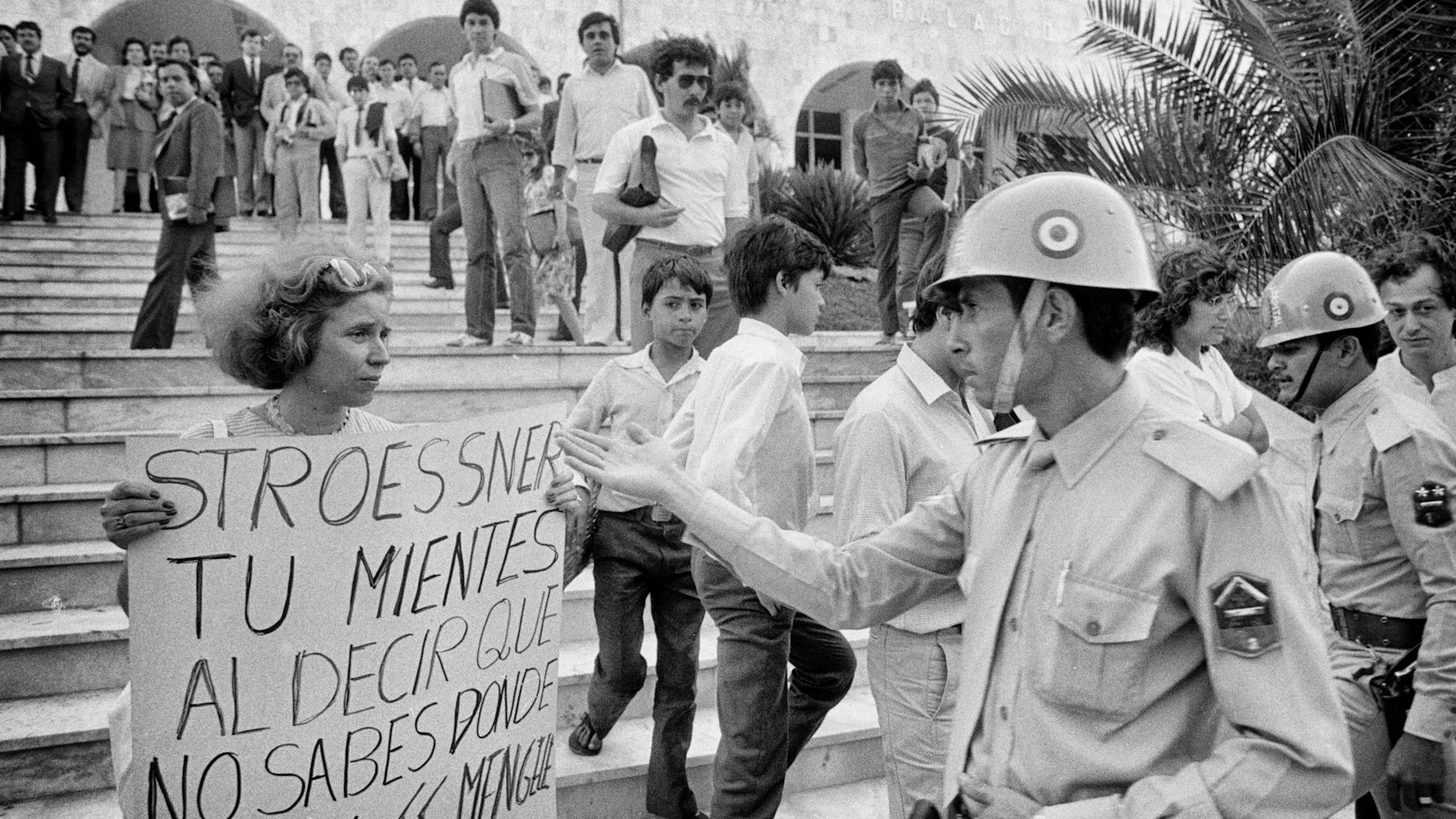 <strong>Beate Klarsfeld 1985 in Paraguay</strong><br><br> Die Journalistin Beate Klarsfeld kämpft seit den 1960er-Jahren dafür, dass Altnazis entlarvt und bestraft werden. Mit Itta Halaunbrenner, deren Kinder auf Befehl des damaligen Gestapo-Chefs von Lyon, Klaus Barbie, von Izieu nach Auschwitz deportiert wurden, demonstriert sie in La Paz. Barbie, der sich jetzt Klaus Altmann nennt, arbeitet für das Innenministerium der dortigen Banzer-Diktatur als Ausbilder für die Sicherheitskräfte.<br><br>1985 fordert Beate Klarsfeld in Asunción die Auslieferung des SS-Lagerarztes Josef Mengele. In Paraguay leben zahlreiche Altnazis, die von Diktator Alfredo Stroessner geschützt werden. Da Paraguay ein wichtiger Handelspartner für die Bundesrepublik ist, blendet die Politik dies aus.