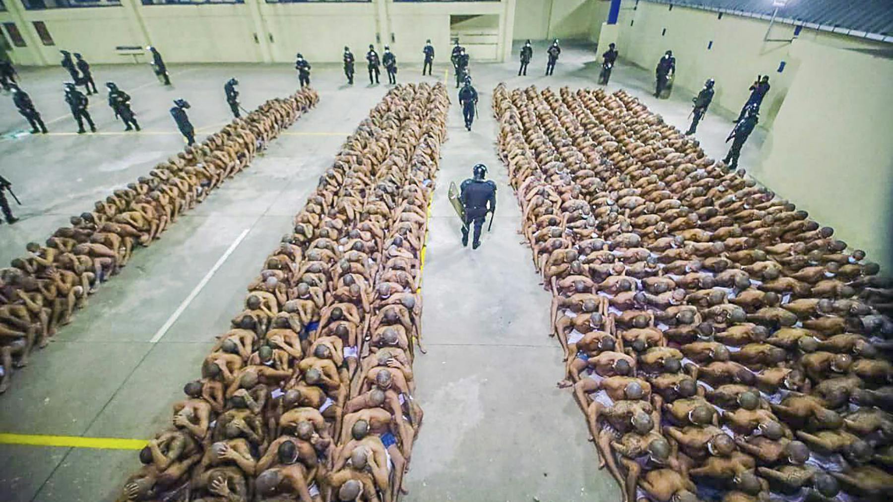 Zwischen den Häftlingen patrouillieren schwer bewaffnete Wachleute.