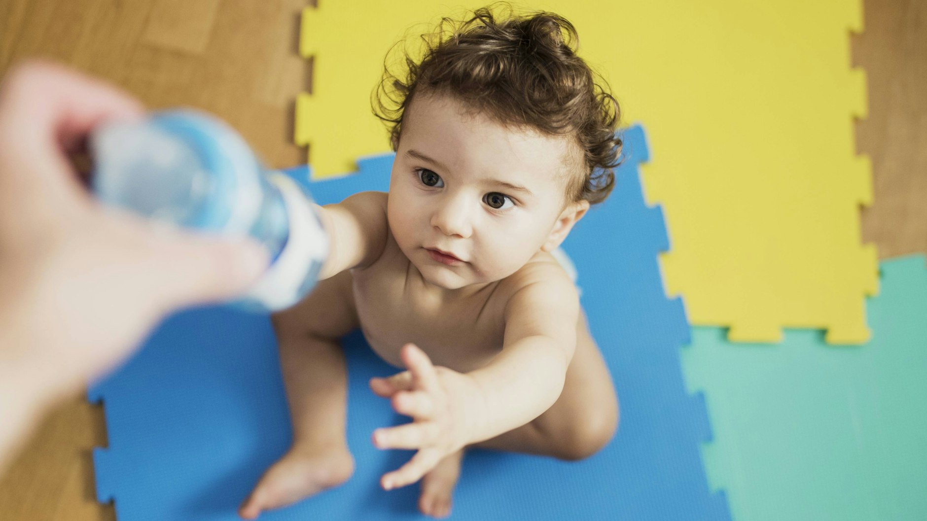 Ein Kind greift zur Trinkflasche.