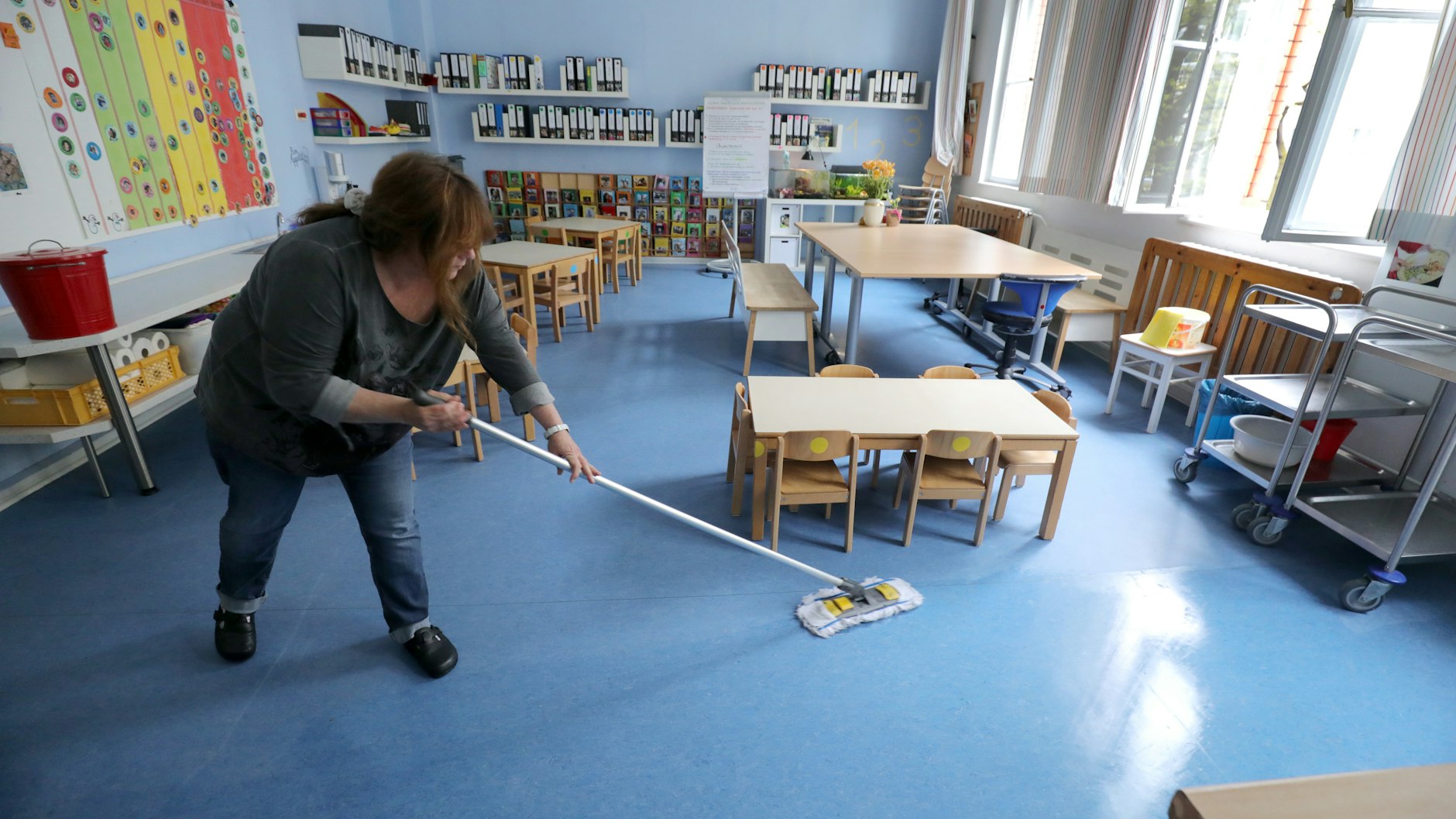 Eine Mitarbeiterin reinigt den Boden. In den Kitas herrschen strenge Hygienevorschriften.
