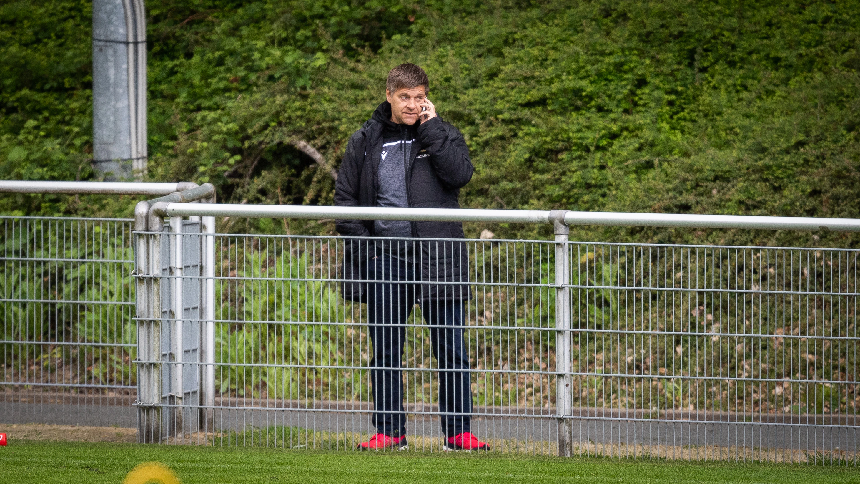 Unions Manager Oliver Ruhnert telefoniert in Barsinghausen, während er das Team beim Training beobachtet.&nbsp;