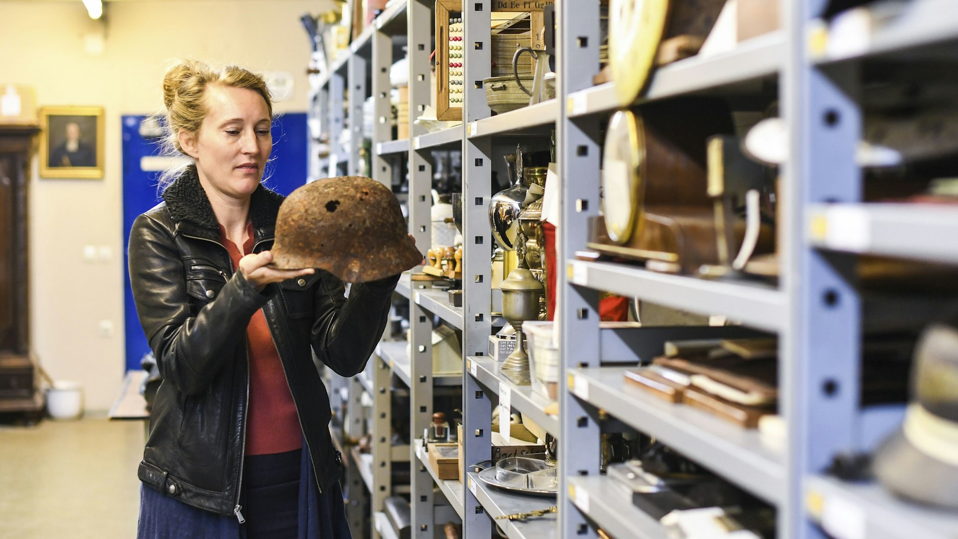 Dr. Urte Evert im Depot ihres Museums. Der rostige, löchrige Stahlhelm weist auf die militärische Vergangenheit der sogenannten Festung Spandau hin.