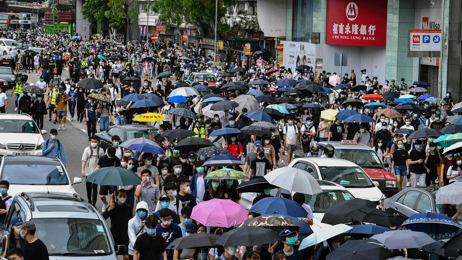 Tausende Menschen gingen im Einkaufsviertel auf die Straße und protestierten gegen striktere Kontrollen durch China.