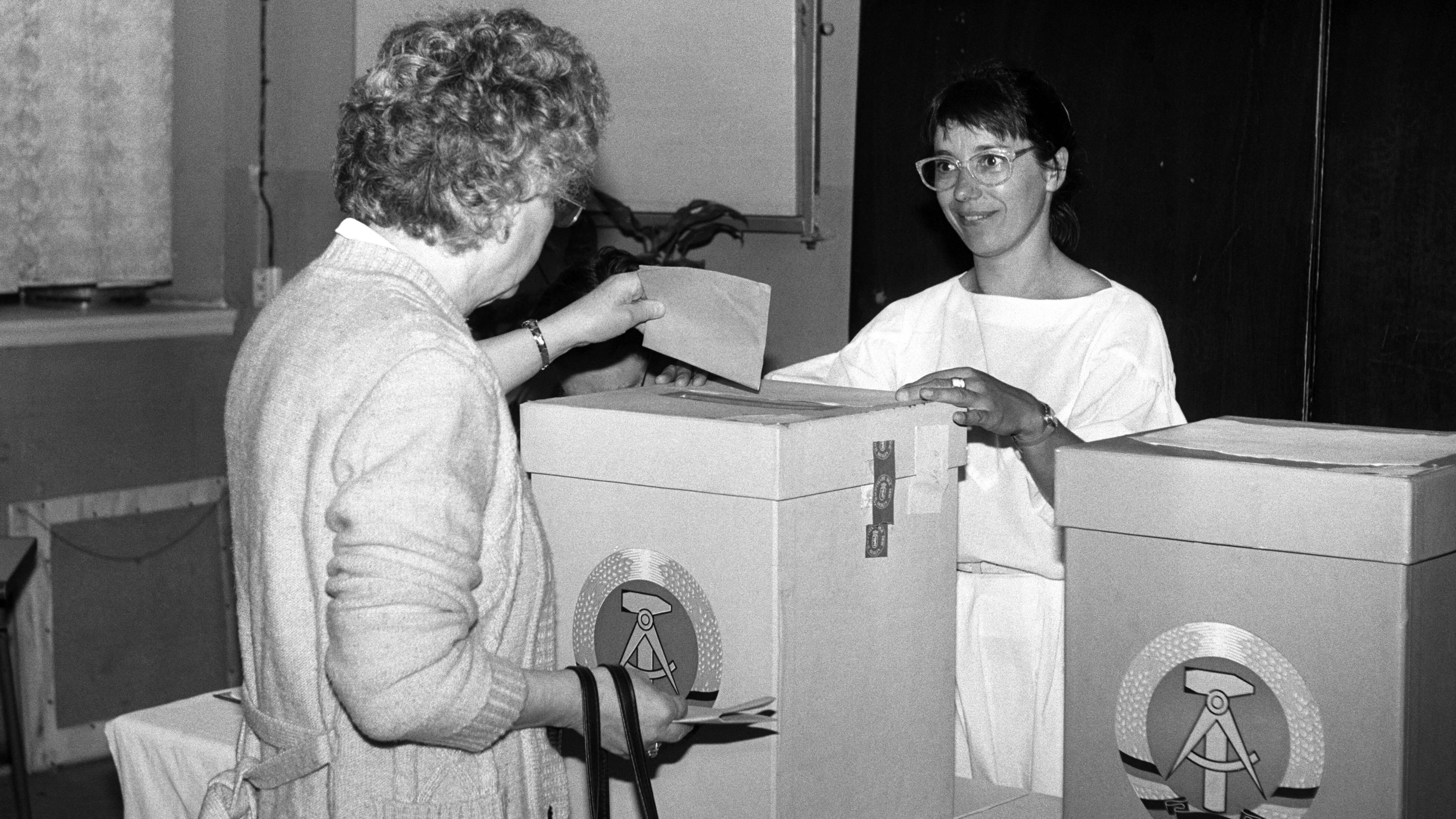 In einem Wahllokal in Prenzlauer Berg gibt eine DDR-Bürgerin ihren Stimmzettel für die Kommunalwahlen ab.