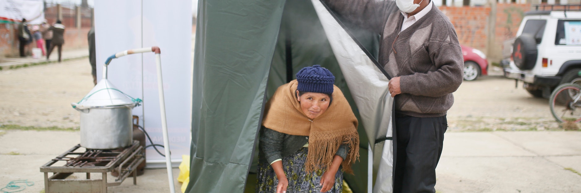 Bolivien: Eine Frau kommt aus einer Dampfkabine, die während der Corona-Pandemie zur Vorbeugung von Erkrankungen der Atemwege an einer Ecke aufgestellt wurde.