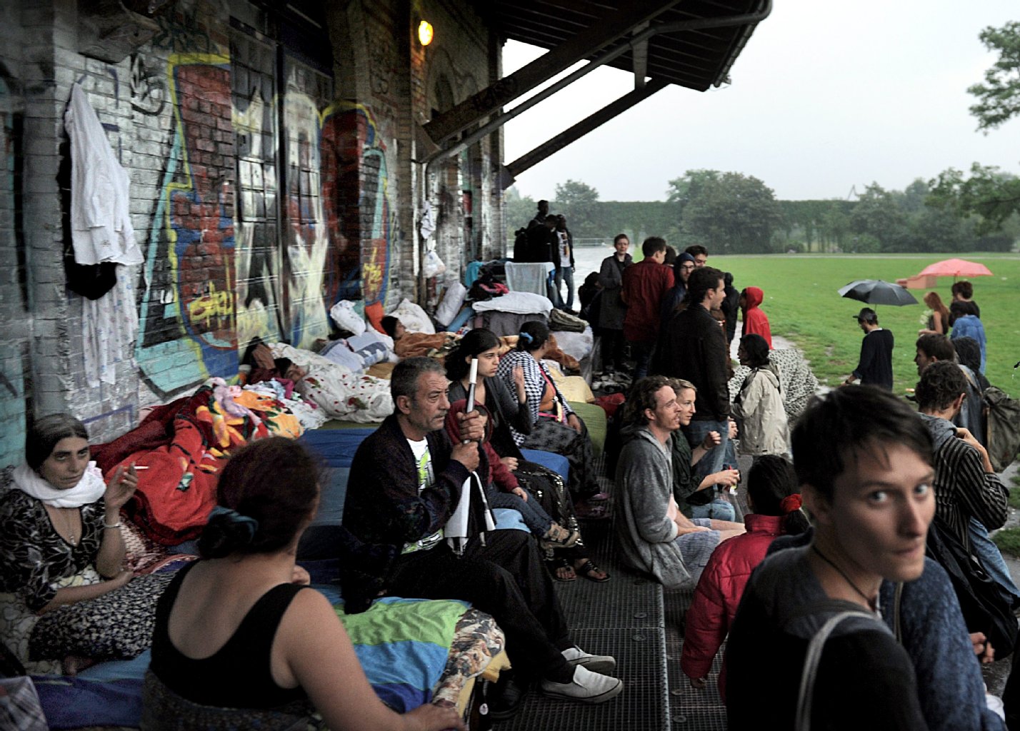 2011: Sinti und Roma Familien haben unter dem Dach des Alten Güterbahnhofes im Görlitzer Park ein Camp errichtet und harren dort bei Regenwetter aus.