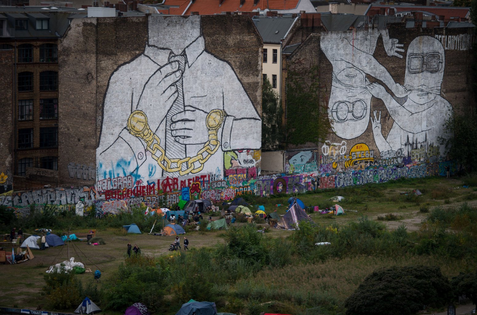Brachen: Sie werden immer weniger und sind aber so beliebt. Hier an der Cuvrystraße in Kreuzberg treffen sich die Berliner zum Feierabendbier. Sie sitzen auf der Erde, genießen zwischen Brandmauern das Feierabendbier. Andere zelten. Bänke, Luxus, Tische? Brauchen die Berliner nicht.