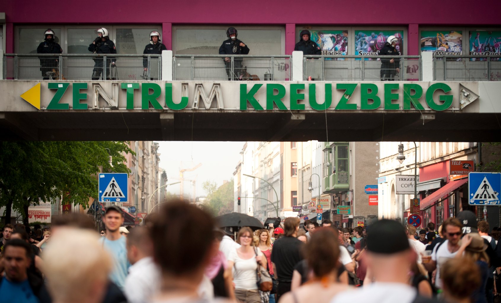 Kotti: Nicht schön, aber ehrlich. Während beim ersten Mai auf dem traditionellen "Myfest" gefeiert wird, bewachen Polizisten das bunte Treiben. Auch sonst ist das Kottbusser Tor Anziehungspunkt in Kreuzberg. Vor allem, weil sich die Oranienstraße ganz in der Nähe befindet. Diese wird immer mehr zur Ausgehmeile: Bars, Shops, Restaurants ziehen jedes Wochenende Tausende an.