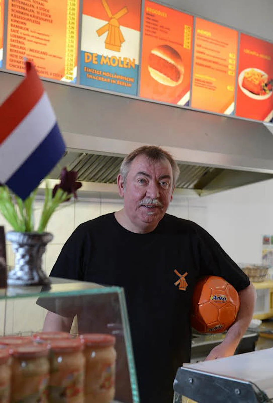 In Uwe Hübners Imbiss tragen Wände, Lampen und Servietten Orange.