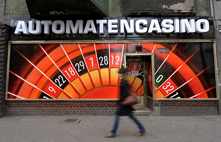 Eine Passantin geht in Neukölln an einer Spielhalle mit der Aufschrift "Automatencasino" vorbei.