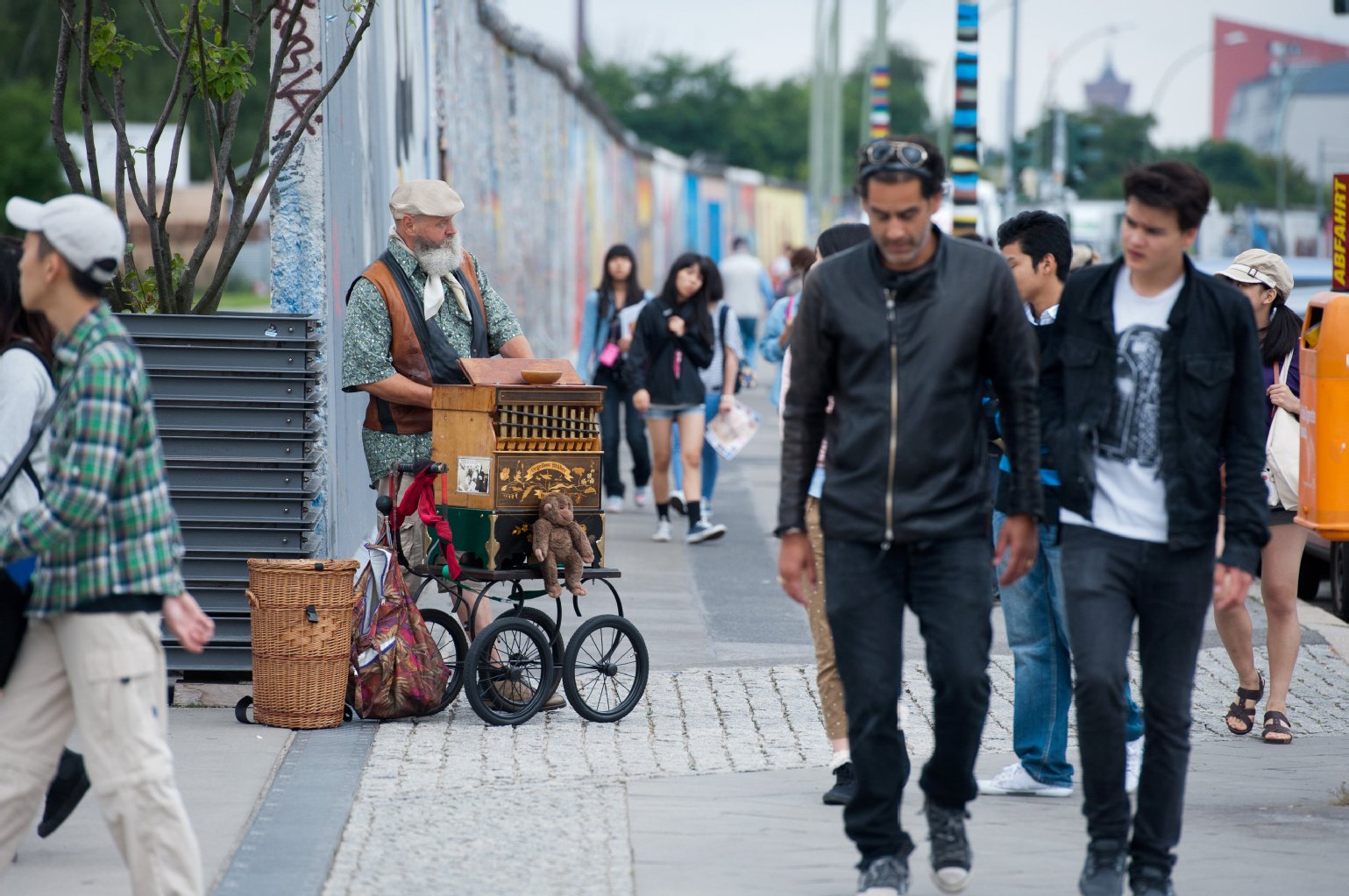 Touristen gehen an Drehorgelspieler Ede vorbei. Sind seine Affen echt?