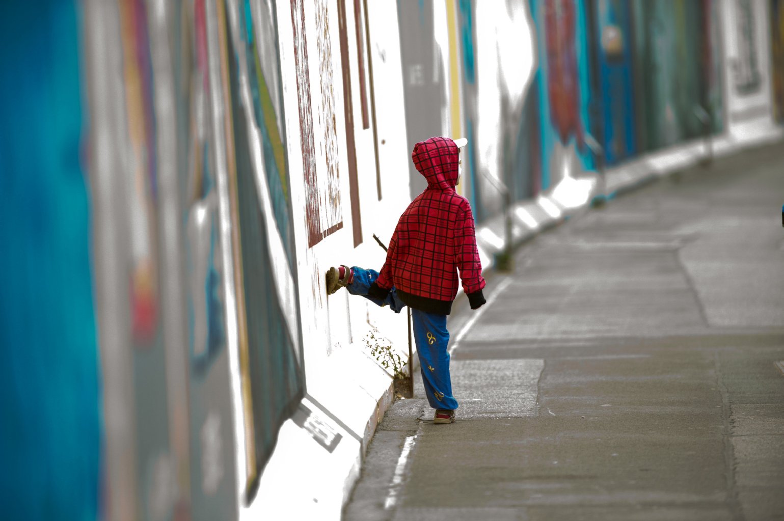 Kinder, Eltern, Schulgruppen und ganze Familien besuchen jeden Tag die East Side Gallery. Hier posiert ein kleiner Tourist.
