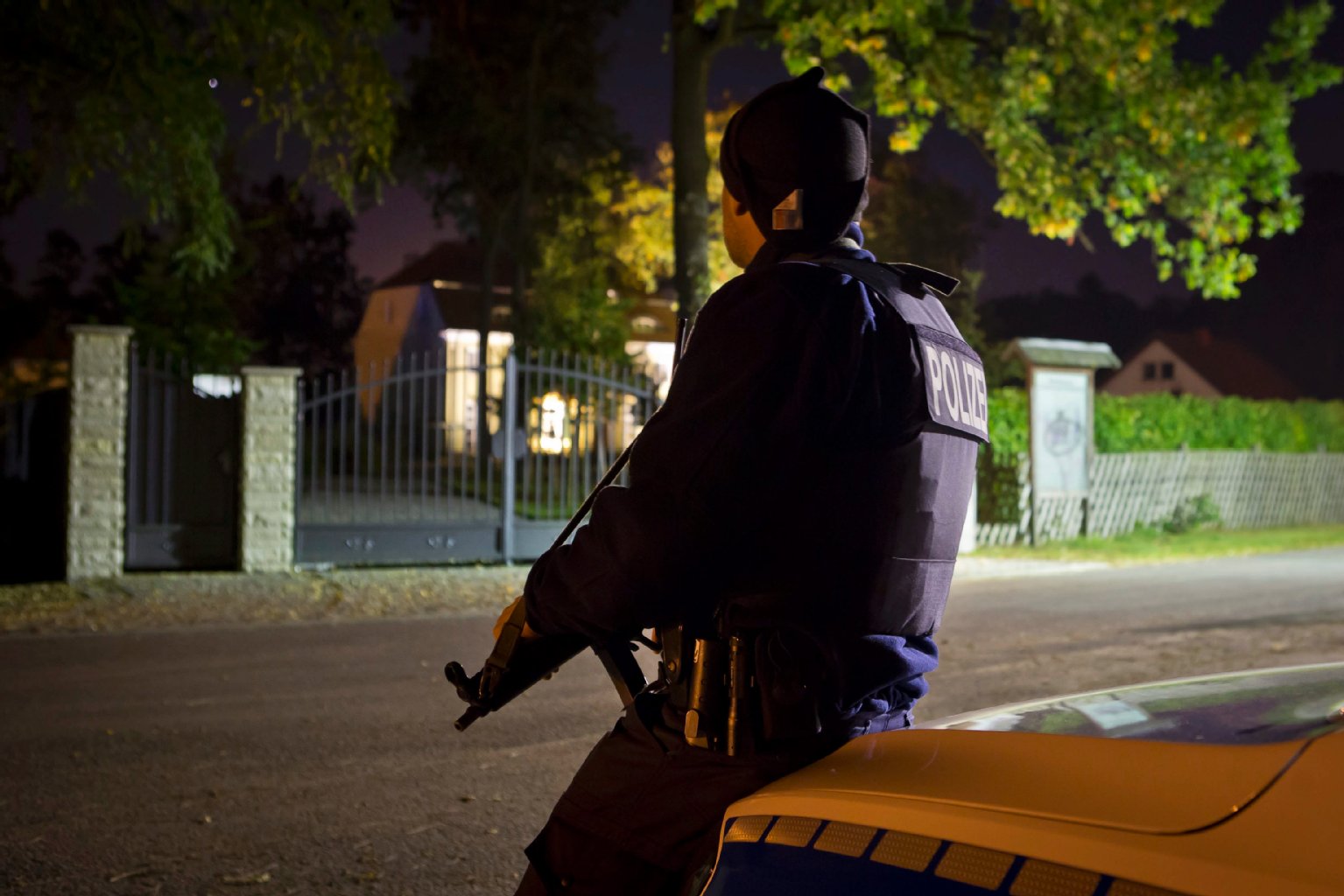 Mit Maschinenpistolen bewaffnete Polizisten bewachen das Anwesen des verschleppten Geschäftsmannes in einem Storkower Ortsteil.
