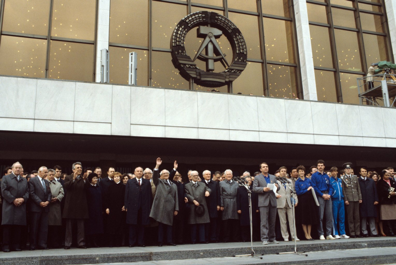 Der Generalsekretär des ZK der SED und Vorsitzende des Staatsrates der DDR, Erich Honecker (winkend links), Michail Gorbatschow (links daneben), Generalsekretär des ZK der KPdSU, und weitere Partei-Funktionäre bei einer Veranstaltung zum XI. Parteitag der SED im April 1986 in Berlin vor dem Palast der Republik.