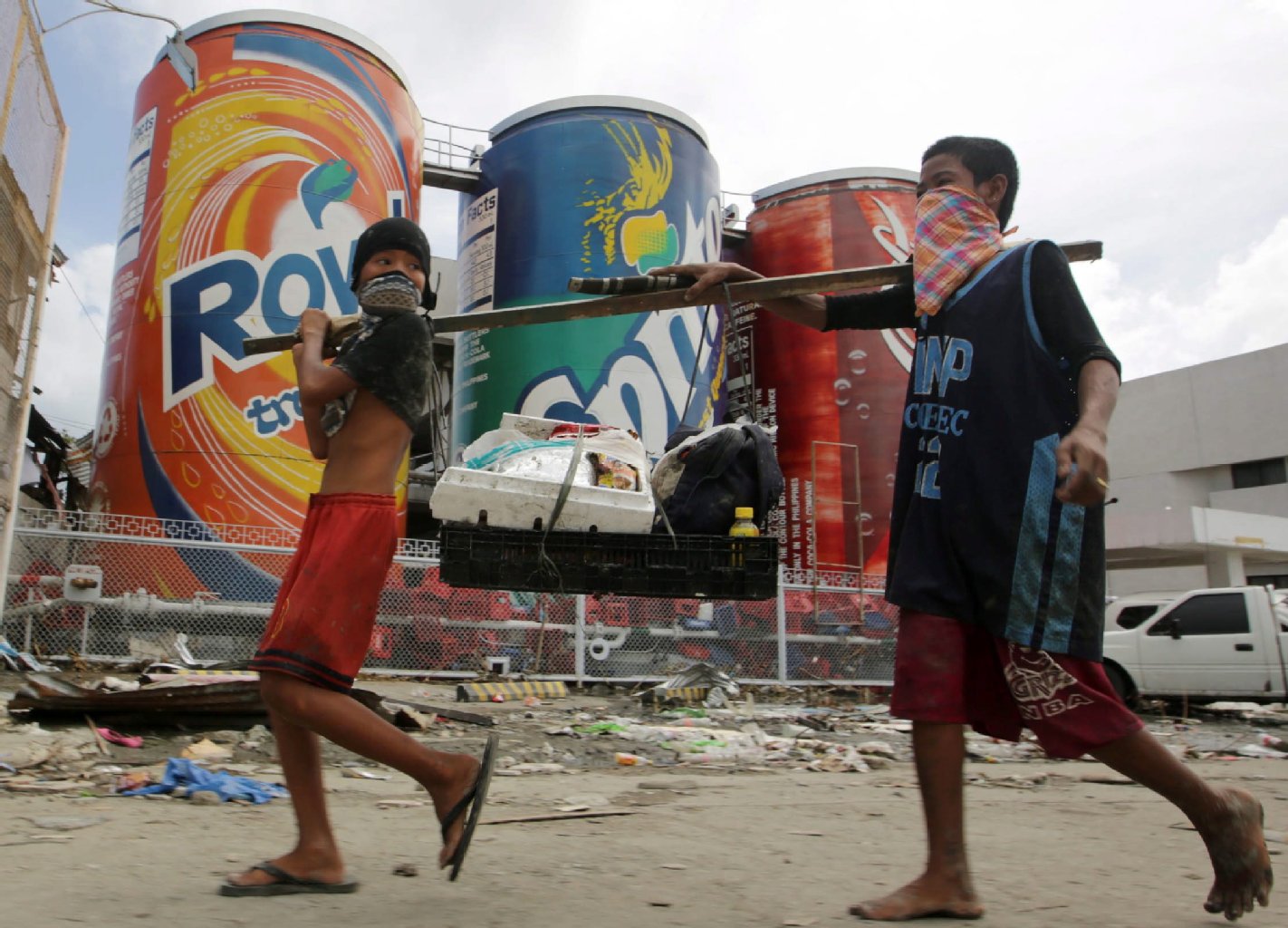 Kinder tragen Hilfsgüter durch die Straßen von Tacloban.