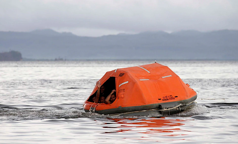 Philippinische Rettungskräfte versuchen, mit einer Rettungsinsel in entlegene Gebiete zu gelangen.