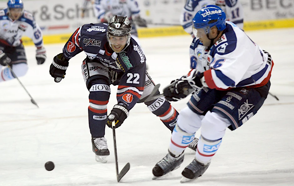 Barry Tallackson (l) von den Eisbären Berlin im Zweikampf mit Jaime Sifers von den Adler Mannheim.