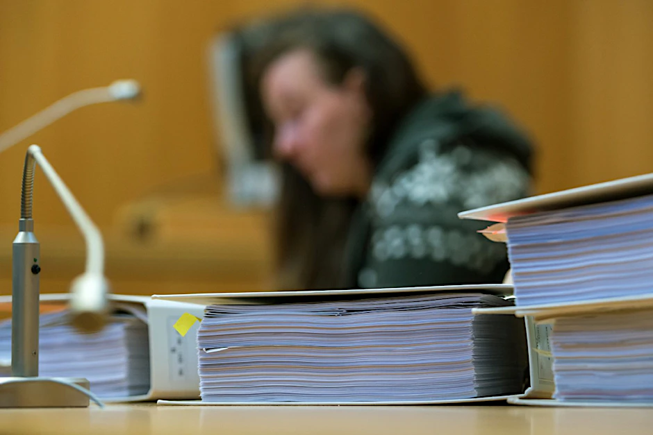 Die Angeklagte im Gerichtssaal des Landgerichts Landshut (Bayern) hinter Aktenordnern.
