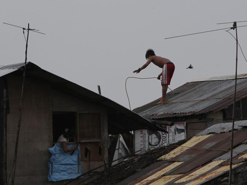 Küstenbewohner befestigen ihr Haus vor dem nahenden Sturm. Foto: Francis R. Malasig