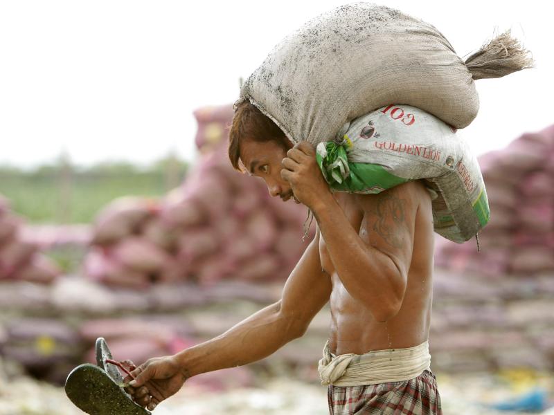 Ein Mann trägt in Manila Sandsäcke zu einem provisorischen Deich. Mittlerweile ist «Haiyan» auf das Festland getroffen. Foto: Francis R. Malasig
