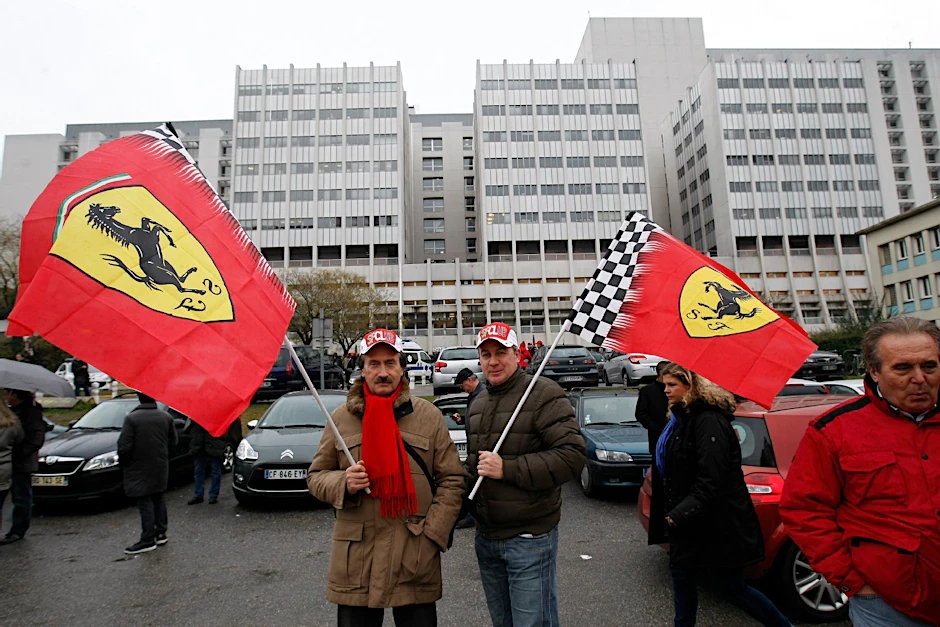 Fans von Michael Schumacher stehen vor dem Krankenhaus in Grenoble, wo der Formel-1-Star nach seinem schweren Ski-Unfall behandelt wird.